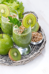 healthy green smoothie with sprouts on a white wooden table