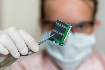 Scientist holding and examining damaged electrical component
