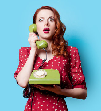girl in red dress with green dial phone