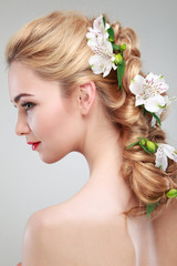 Obraz na płótnie Canvas Beautiful girl with varicoloured flowers in hairs