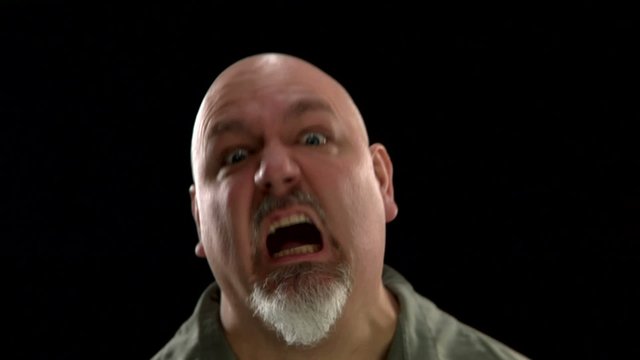 A fat bald white man makes crazy rage faces