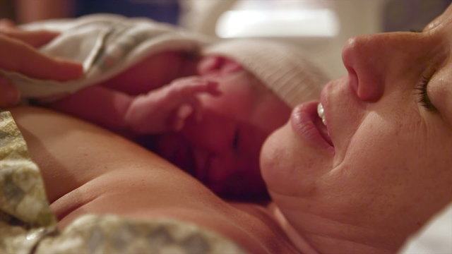 A tired mother with her newborn baby that was born minutes before