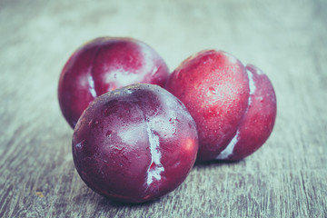 plums on wood background with filter effect retro vintage style