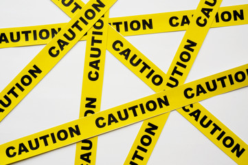 Yellow Caution tapes crossing on white background