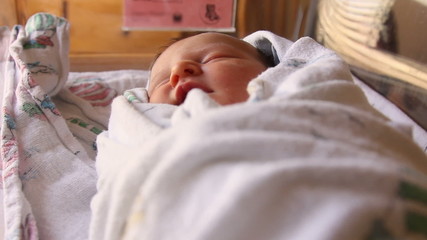 A newborn baby sleeping in the hospital crib after being born - Powered by Adobe