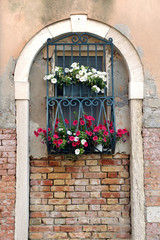 Fototapeta na wymiar Window in Arch with Iron Bars and Flower Boxes
