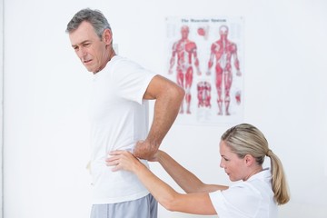 Doctor examining her patient back 