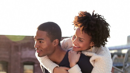 couple spend time together on a roof top laughing and looking into the distance