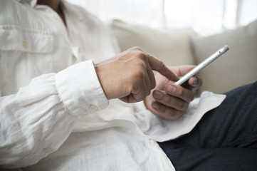 Men are using a smart phone at home sofa