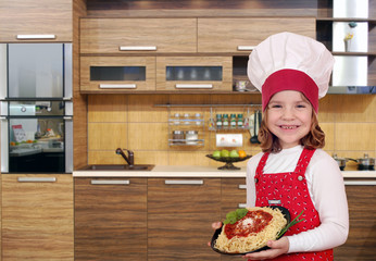 happy little girl cook with delicious spaghetti in kitchen