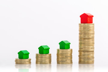 Houses stacked on rising golden coins.