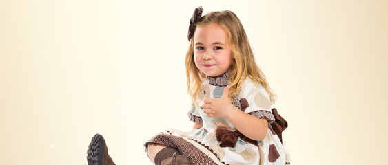 Little blonde girl with thumb up