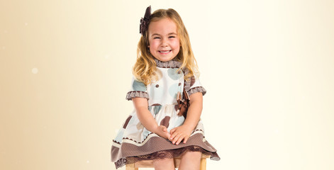 Little blonde girl sitting on chair