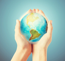 close up of human hands with earth globe