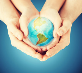 close up of woman and man hands with earth globe