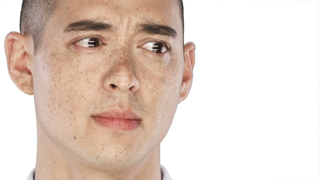 Asian Man looks sad with tears in his eyes into the camera on a white background