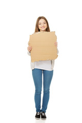 Teen woman holding cardboard sheet.