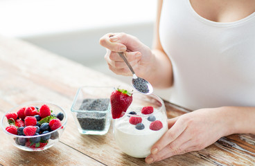 close up of woman hands with yogurt and berries