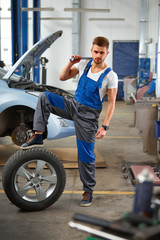 Fototapeta na wymiar Auto repair service. Handsome young mechanic.