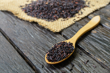 Close up of riceberry in spoon on wooden