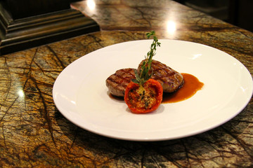 Delicious steak with sauce served in a white plate.