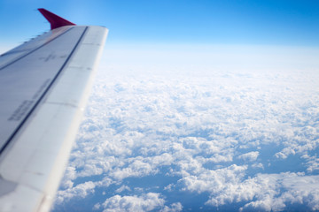 Fototapeta na wymiar Looking to clouds through airplane window