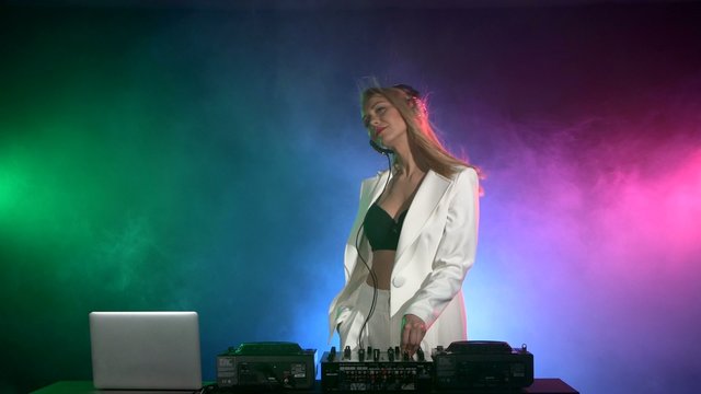 Attractive dj girl in sexy clothes in white jacket and black top