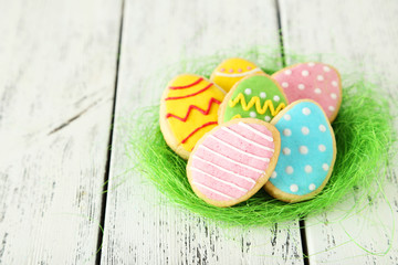Easter eggs in nest on white wooden background