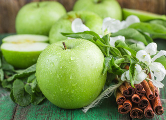 Green apples, mint and cinnamon on the table