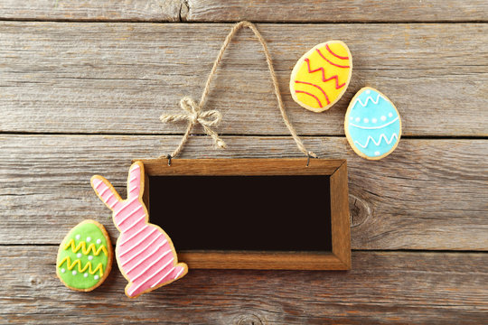 Colorful easter cookies with frame on grey wooden background