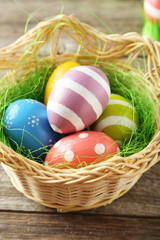 Easter eggs in basket on grey wooden background
