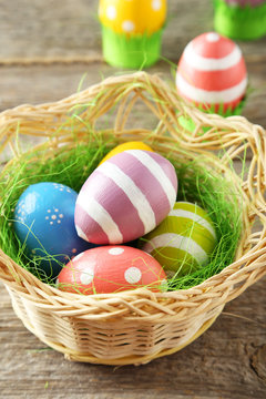 Easter eggs in nest on grey wooden background