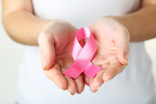 Female hands holding pink ribbon, healthcare and medicine concep