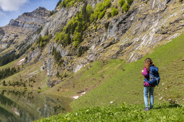 Naklejka na ściany i meble Woman tourist with backpack hiking on Alps