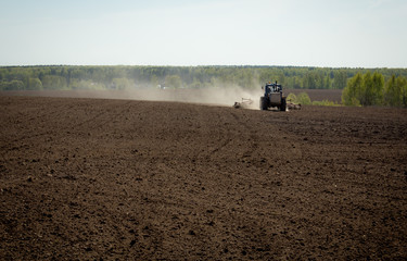 Fototapeta premium Tractor in plowed field