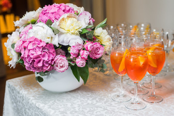 Orange exotic cocktail served at the table with a bouquet 