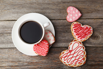 Heart cookies with cup of coffee on grey wooden background