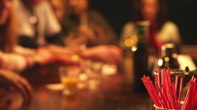 The camera focuses in front of all the people as they go about drinking together