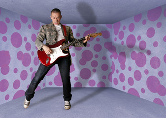 punk man in cardboard room with the guitar