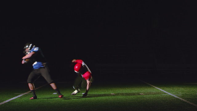 A football player running with the ball runs into and spins around a defender 