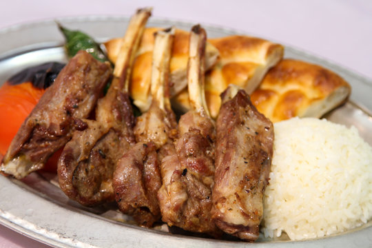 Delilcious lamp chops served in a white plate.