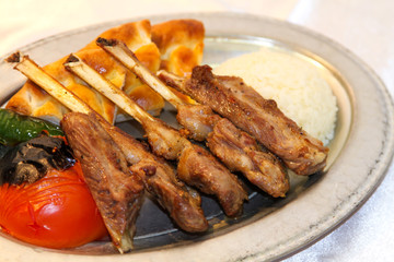 Delilcious lamp chops served in a white plate.