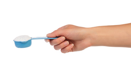 Measuring cup with washing powder in hand