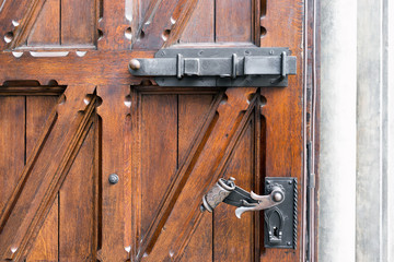 Wooden vintage door with wrought-iron locks and bars