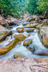 Jungle waterfall with flowing water, large rocks © Biskariot