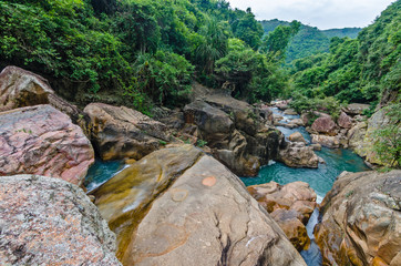 Jungle waterfall with flowing water, large rocks © Biskariot