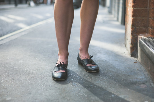Legs of woman standing on the pavement