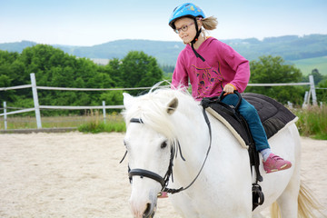Mädchen reitet auf Pferd