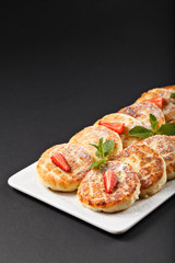 Hot tasty small cheesecakes with strawberry and mint
