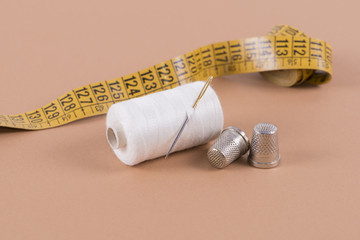 Thread, needle, thimble and measuring tape
